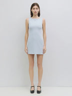 Woman wearing a light gray sleeveless dress on a white background