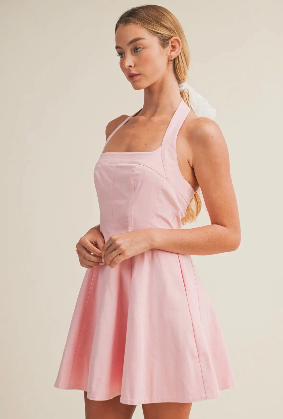 Woman wearing a pink dress against a plain background