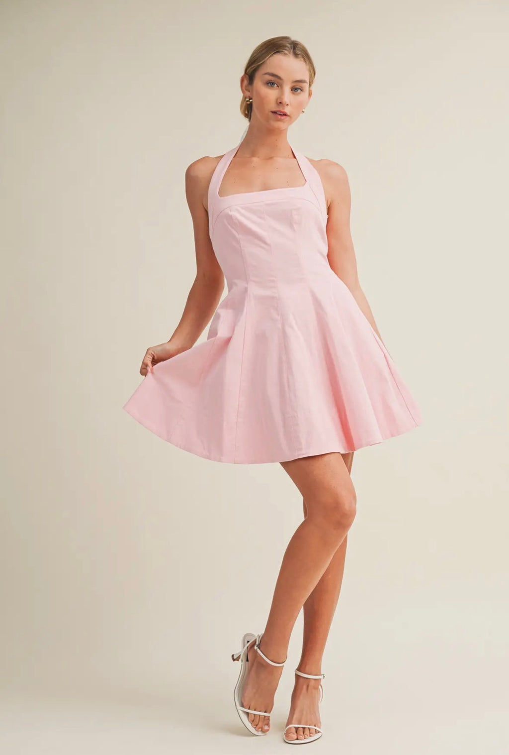 Woman wearing a pink dress against a plain background