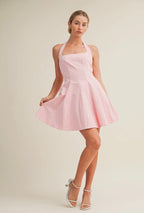 Woman wearing a pink dress against a plain background