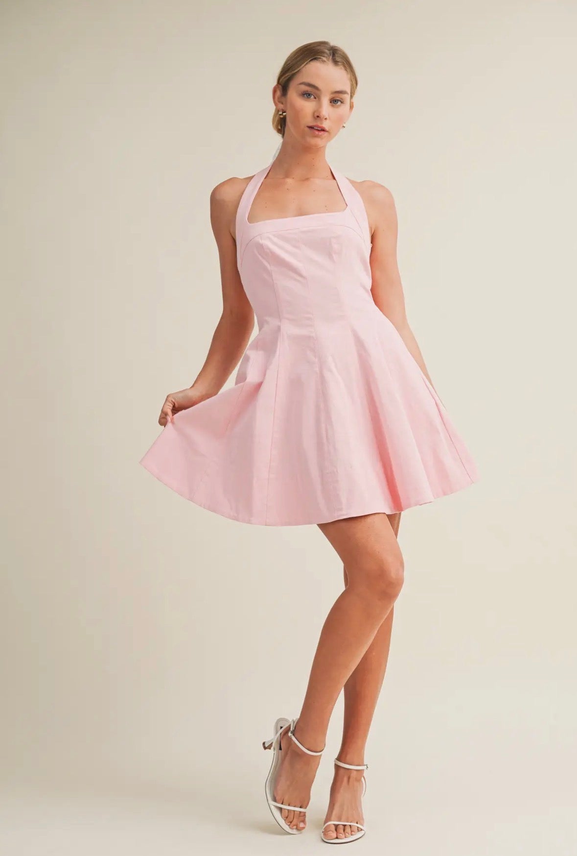 Woman wearing a pink dress against a plain background