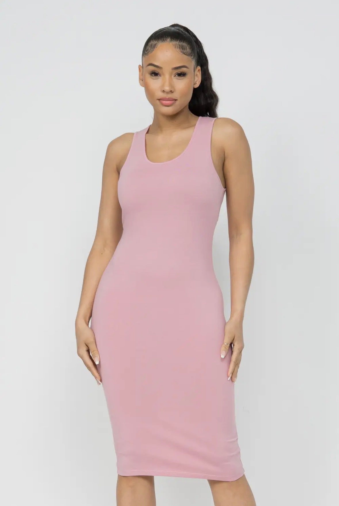 Woman wearing a pink sleeveless dress against a white background
