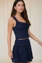 Woman wearing a navy blue dress against a plain background