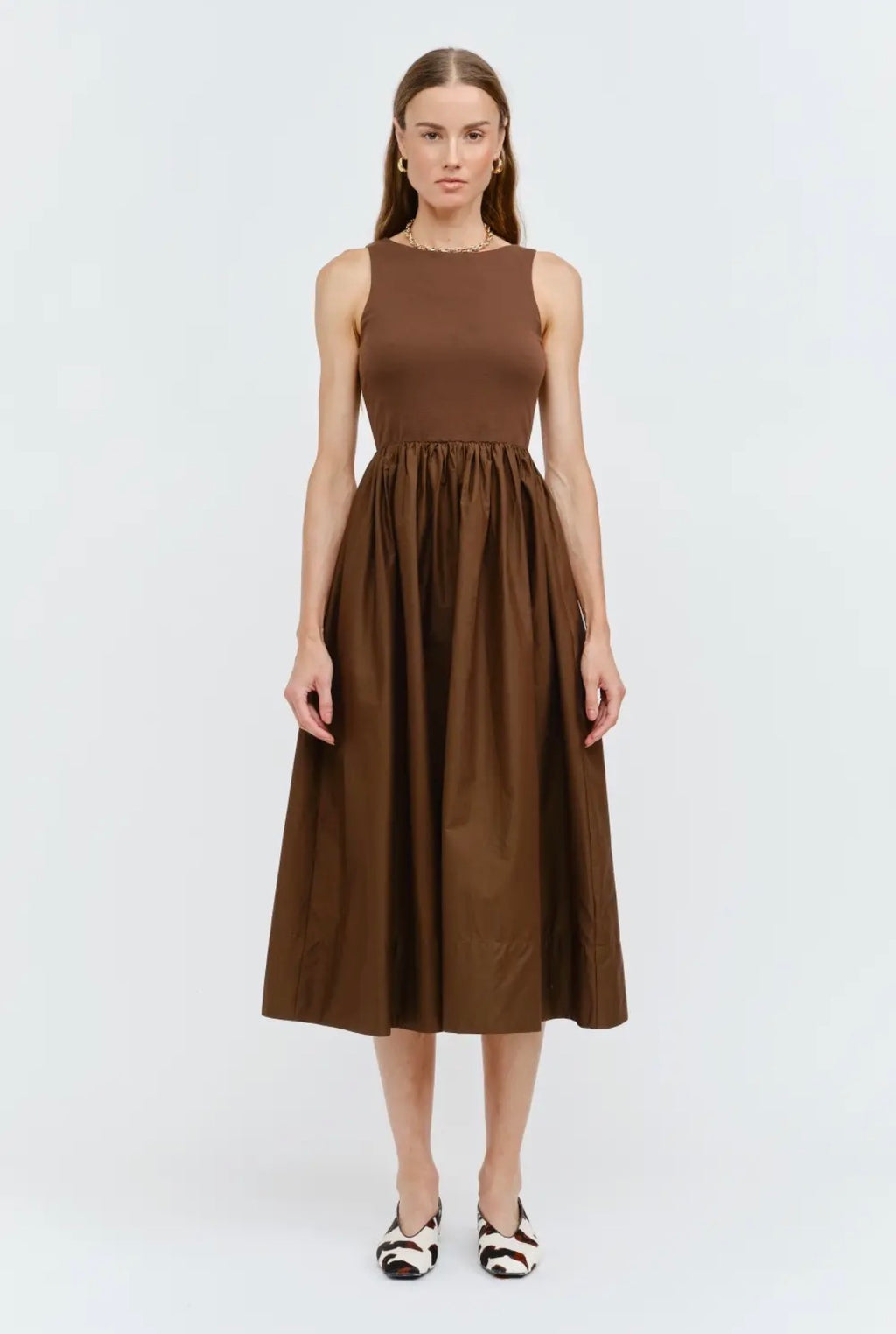 Woman wearing a brown sleeveless dress on a white background