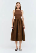 Woman wearing a brown sleeveless dress on a white background