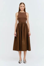 Woman wearing a brown sleeveless dress on a white background