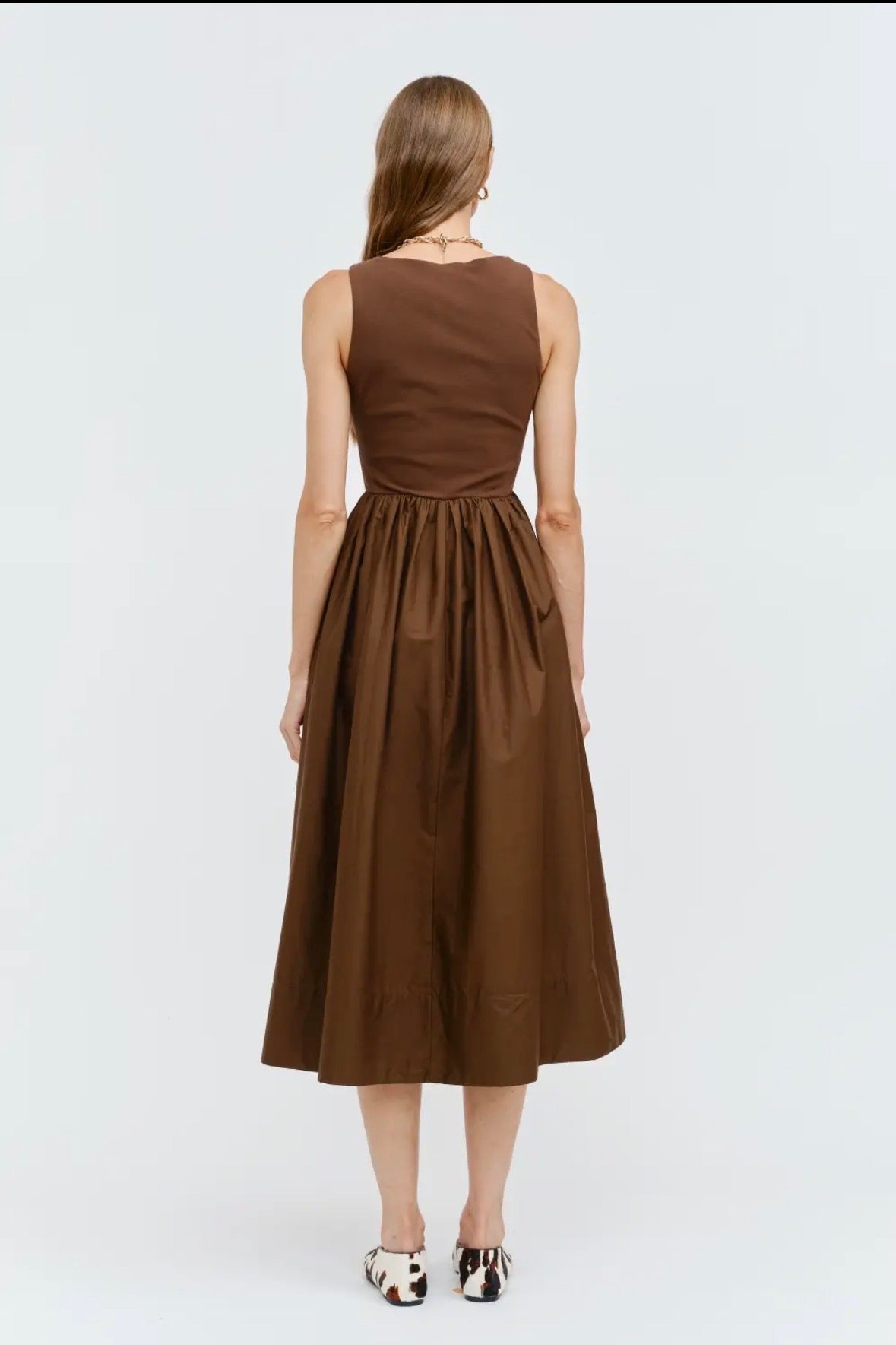 Woman wearing a brown dress on a white background