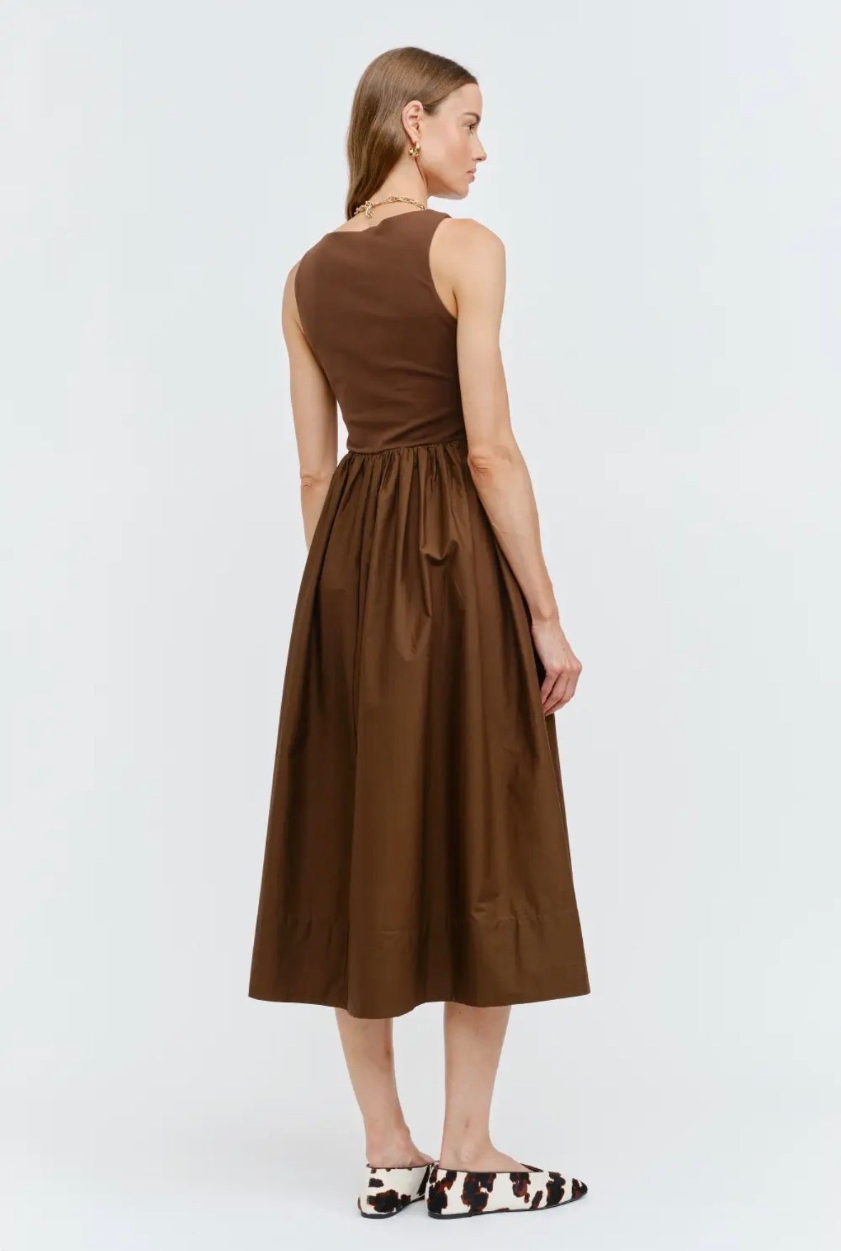Woman wearing a brown dress on a white background